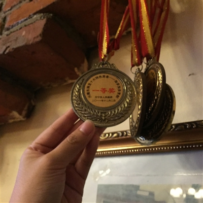 梁惠贞老人参加美食比赛时获得的奖牌。（《三亚日报》）
