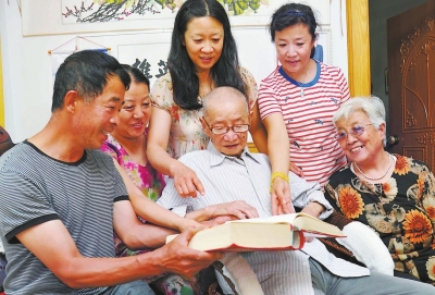 一家人围在一起，饶有兴趣地翻阅永定苏氏族谱。