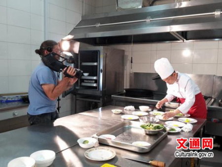 罗马尼亚国家电视台记者在拍摄中国厨师的厨艺展示（闫建武 摄）