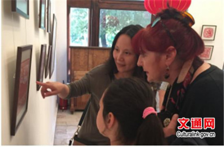 中国使馆文化官员向观众介绍剪纸艺术