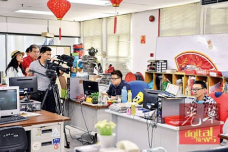 拍摄队伍拍摄本报编采部工作过程。（马来西亚《光华日报》）