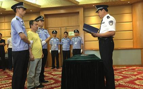 海关缉私警向黄某宣读犯罪嫌疑人诉讼权利义务告知书。蔡岩红摄 海关缉私警向黄某宣读犯罪嫌疑人诉讼权利义务告知书。蔡岩红摄