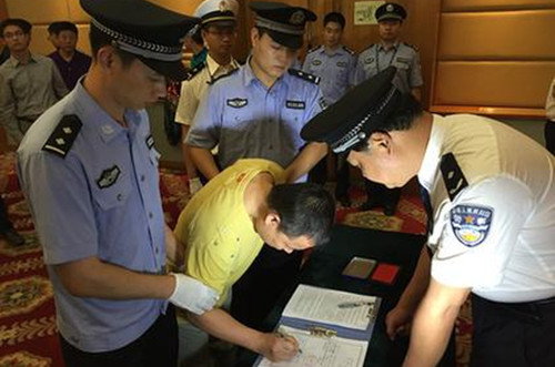 黄某在逮捕证上签字。蔡岩红摄 黄某在逮捕证上签字。蔡岩红摄