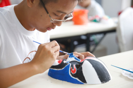8月1日,一名来自法国的华裔男孩绘制他设计的京剧脸谱。(法国《欧洲时报》/王骏 摄) 8月1日,一名来自法国的华裔男孩绘制他设计的京剧脸谱。(法国《欧洲时报》/王骏 摄)
