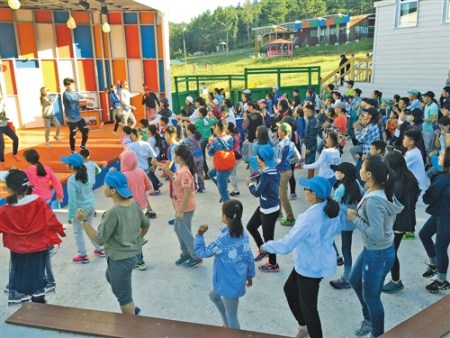 夏令营的老师教小朋友们跳街舞。