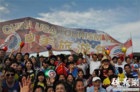 快闪活动参加者在“中美旅游年”横幅前合影留念。(《侨报》记者徐一凡摄)