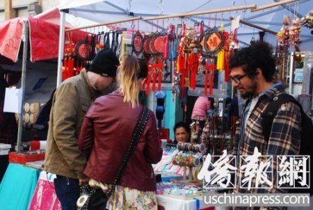 白人游客也来逛街会，对中国手工艺品爱不释手。(美国《侨报》/吴卓明 摄)