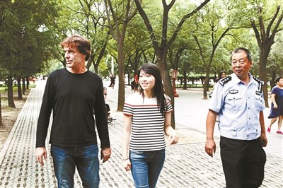 女孩和养父、民警在一起。(图片来源：北京青年报)