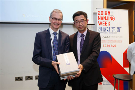 南京市委宣传部副部长潘谷平(右)向大英图书馆东亚藏品部主任Hamish Todd赠送来自南京的书籍。
