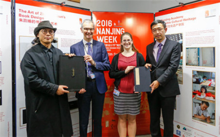南京市委宣传部副部长潘谷平(右一)、书籍装帧设计师朱赢椿(左一)向大英图书馆赠送礼物。