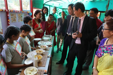 尼泊尔小学生展示自己制作的饺子等中国食物