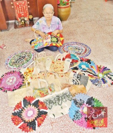 李美龄展示亲手缝制的环保手提袋及地垫。(马来西亚《光华日报》)