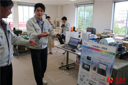 王社长让工作人员展示小型辐射监测仪与读取器。 王社长让工作人员展示小型辐射监测仪与读取器。