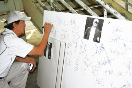 前来悼念的华人都在纸板上签了名。（美国《世界日报》/冯鸣台 摄）