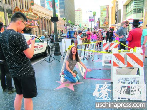 一对情侣在留影拍照时并不知道这是特朗普之星被破坏现场。(美国《侨报》/翁羽 摄) 一对情侣在留影拍照时并不知道这是特朗普之星被破坏现场。(美国《侨报》/翁羽 摄)