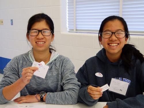 马州蒙郡中学生Alisa Leung(左)及Heidi Leung(右)担任投票义工，发放“我已投票”贴纸。(美国《世界日报》/胡毓玲 摄)