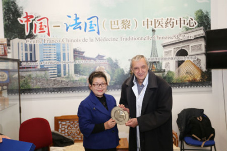 熊磊校长向包默鲁主任赠送云南中医学院纪念盘。（图片来源：本版照片均由黄冠杰 摄）