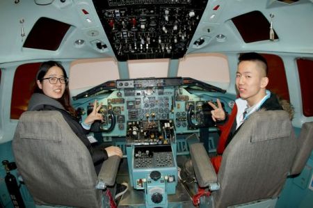 在羽田机场参观时两位同学兴致勃勃地坐上日航的飞机模拟驾驶舱