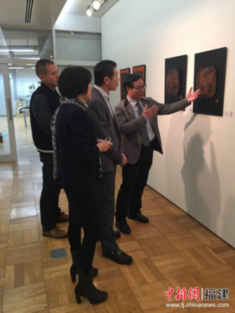 周榕清(右一)向来参观的日本黄檗文化促进会理事长陈熹(右二)等旅日华侨介绍其漆艺作品。