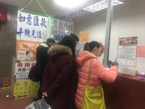 春节将至，不少华裔民众纷纷前往各个汇款点给家人汇款。(美国《世界日报》/黄伊奕 摄)
