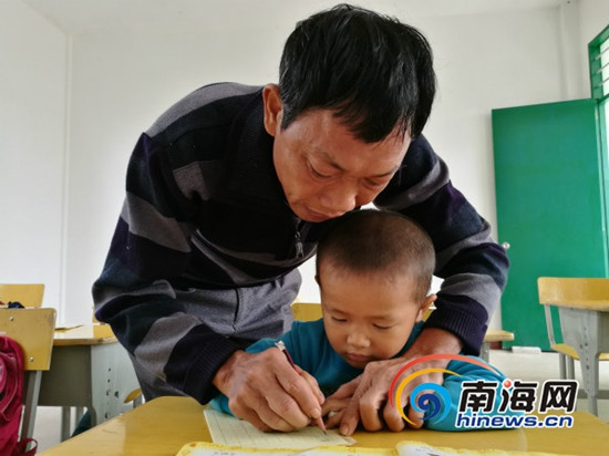 吴光明教孩子们写字。南海网记者 高鹏 摄 吴光明教孩子们写字。南海网记者 高鹏 摄