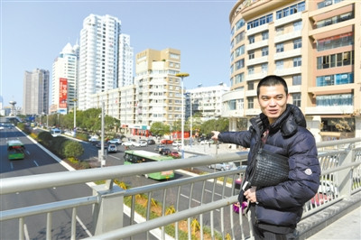 在新城天桥上,童洪建对家乡巨变赞赏有加。杨冰杰 摄 在新城天桥上,童洪建对家乡巨变赞赏有加。杨冰杰 摄