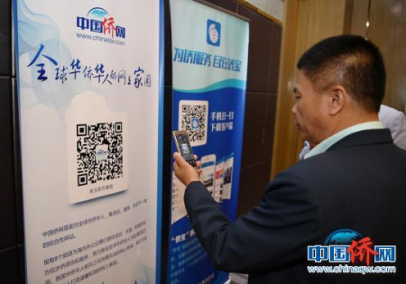 海外华助中心代表用手机扫中国侨网微信公众号
