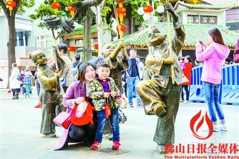 禅城祖庙景区,一对母子正在景区门前的雕塑前拍照。/佛山日报记者王澍摄 禅城祖庙景区,一对母子正在景区门前的雕塑前拍照。/佛山日报记者王澍摄