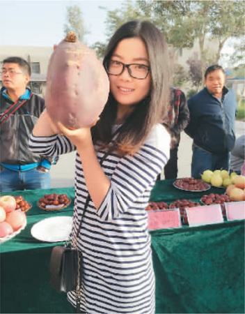 赵闫和职工们参加美食节，展出了很多特色农产品。她展示的是一个大红薯。