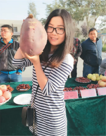 赵闫和职工们参加美食节,展出了很多特色农产品。她展示的是一个大红薯。 赵闫和职工们参加美食节,展出了很多特色农产品。她展示的是一个大红薯。
