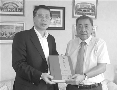福建省侨办主任冯志农（左）向菲宋庆龄基金会创会会长陈祖昌赠送《福建家训》。