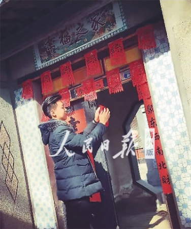 春节前夕，王前回到老家，帮助父母在家门上贴对联、挂福字。