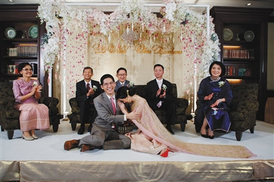 上海姑娘李楠在泰国与男朋友成功完婚,婚礼上,李楠遵照泰国习俗向丈夫行拜礼.
