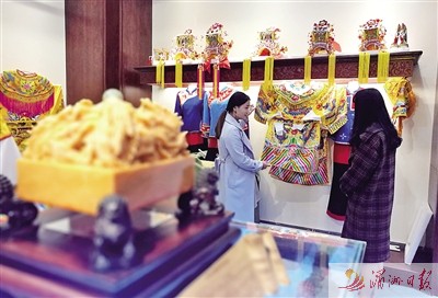 会馆工作人员向市民介绍妈祖服饰。 会馆工作人员向市民介绍妈祖服饰。