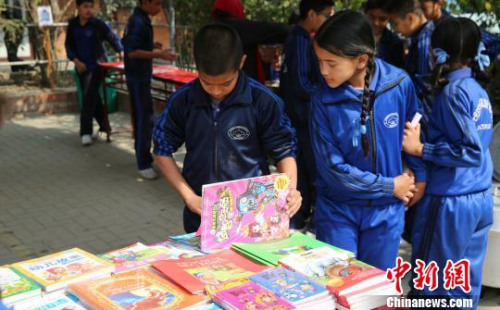 尼泊尔学生正在翻看中文书籍。　张晨翼　摄