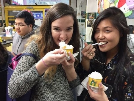 Julia Lee(右)带着从西雅图来纽约旅游的Rachel Becker(左)来到华埠玩，趁着天气热一起吃雪糕。(美国《世界日报》/俞姝含 摄)