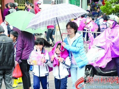 2月22日上午十点多，在市区一所小学门口，家长们撑着伞接送学生放学回家。