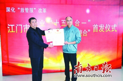 江门市市长邓伟根(右)向江门航天数联科技有限公司总经理石磊颁发全国首张“十五证合一”的企业法人营业执照。全泽超 摄 江门市市长邓伟根(右)向江门航天数联科技有限公司总经理石磊颁发全国首张“十五证合一”的企业法人营业执照。全泽超 摄