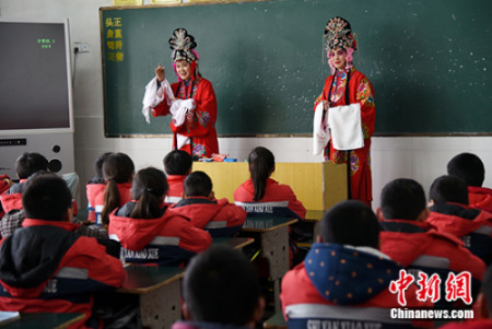 图为非遗传承人向小学生们讲授“四平调”知识。 崔猛 摄 图为非遗传承人向小学生们讲授“四平调”知识。 崔猛 摄