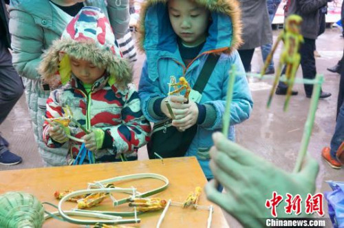 图为两个小朋友被“会翻筋斗的猴子”吸引住了。 赵琳露 摄 图为两个小朋友被“会翻筋斗的猴子”吸引住了。 赵琳露 摄