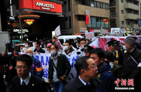 2月5日下午，近百名在日华侨华人和中国留学生在东京举行了抗议APA酒店的和平游行活动，抗议APA酒店长期在所有客房中放置由该集团老板元谷外志雄撰写的否认、歪曲历史的右翼书籍。图为游行队伍经过APA在新宿的一间酒店。<a target='_blank' href='http://www.chinanews.com/'>中新社</a>记者 王健 摄