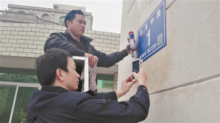 晋江市的公安民警在安装二维码门楼牌(蔡福仁 摄) 晋江市的公安民警在安装二维码门楼牌(蔡福仁 摄)