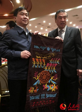 侨办主任秦春成向广西乡亲赠送家乡美丽的壮锦。(谢荣镇摄) 侨办主任秦春成向广西乡亲赠送家乡美丽的壮锦。(谢荣镇摄)