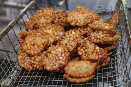 花生饼从油锅中捞上来,呈金麦色的色泽。(马来西亚《星洲日报》) 花生饼从油锅中捞上来,呈金麦色的色泽。(马来西亚《星洲日报》)