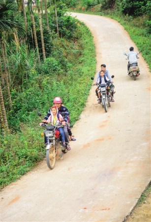 两位吴老师每天骑摩托车接送离校较远的孩子们上学。因为山路弯弯，学生徒步上学费时不少。