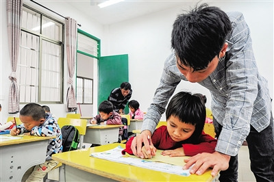 吴志平教学生写字,父亲吴光明也没有闲着。 吴志平教学生写字,父亲吴光明也没有闲着。