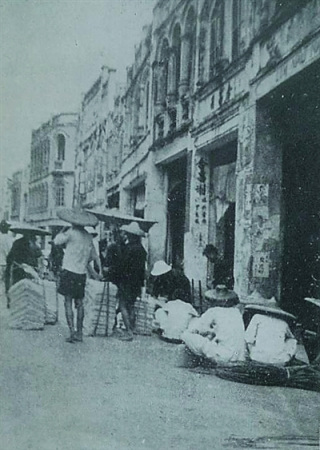 1939年，琼海嘉积街上戴斗笠的人们。
