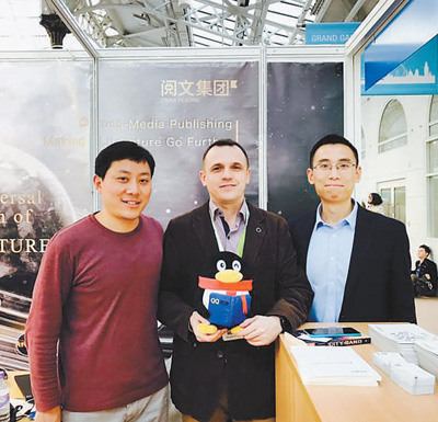 2017年3月，伦敦国际书展上，外国读者在中国阅文集团展台与工作人员合影。 　　本报记者 李应齐摄