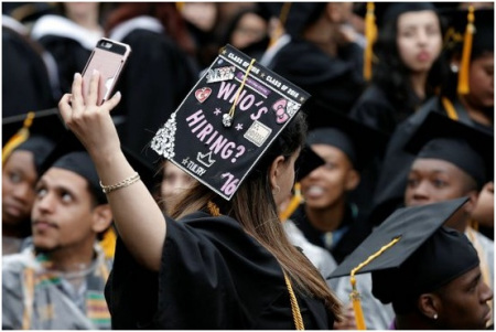 一名纽约市立大学城市学院的毕业生3日在方帽子上写着“谁来雇我？” (美国《世界日报》援引路透社)