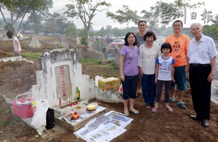 陈载金（左一）带着孩子与家人一同扫墓。（马来西亚《星洲日报》）